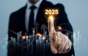A person in a suit touches a digital screen displaying upward arrows and bar graphs, highlighting "2025.