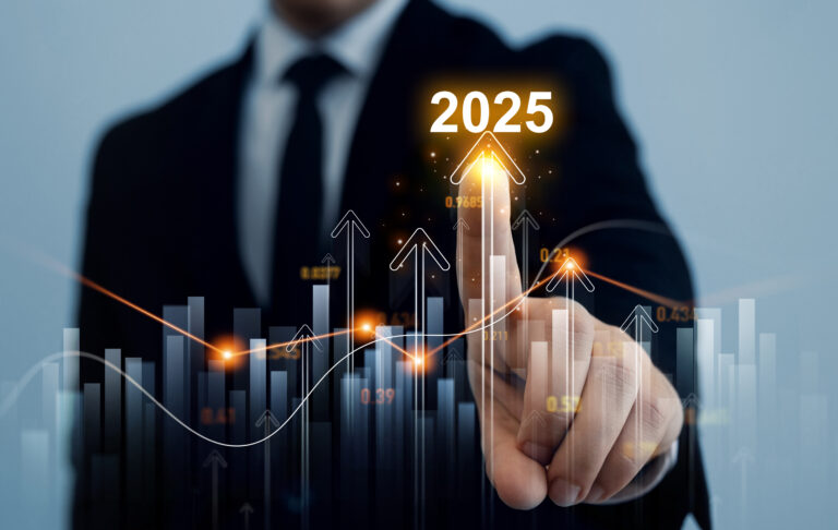 A person in a suit touches a digital screen displaying upward arrows and bar graphs, highlighting "2025.